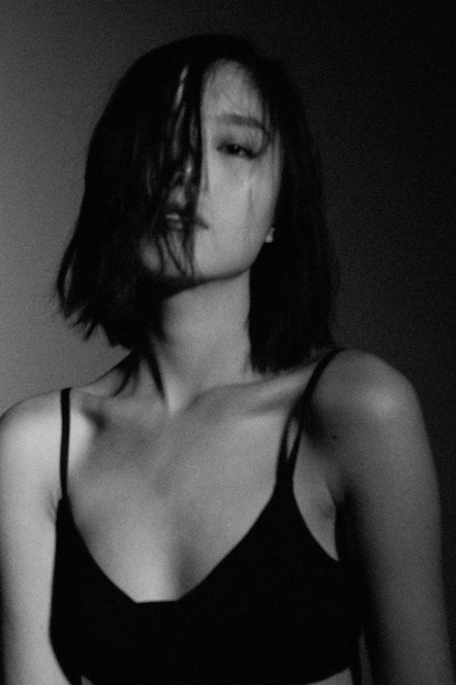 A grainy black-and-white portrait of a short-haired woman