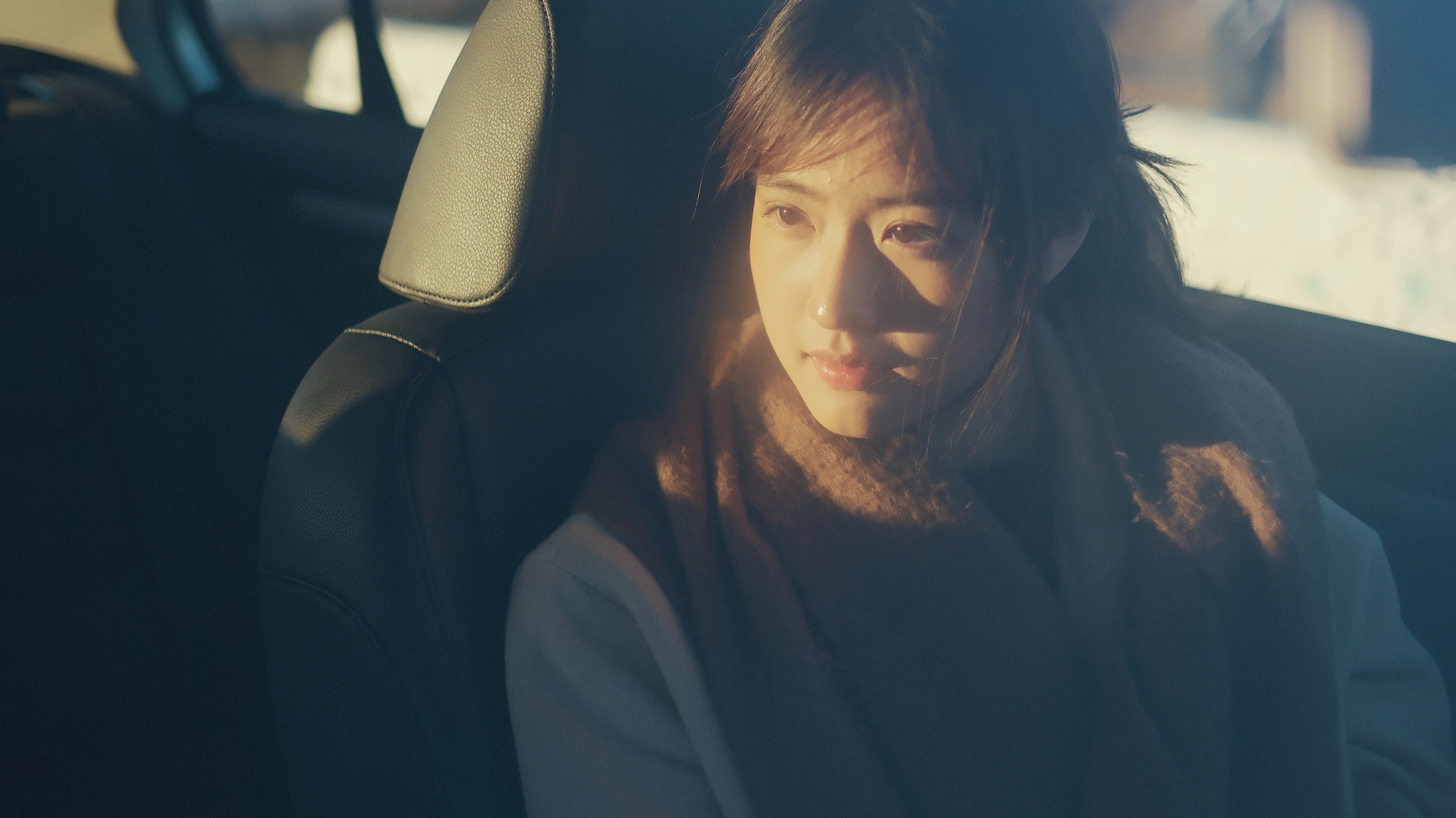 A woman beside a car at golden hour
