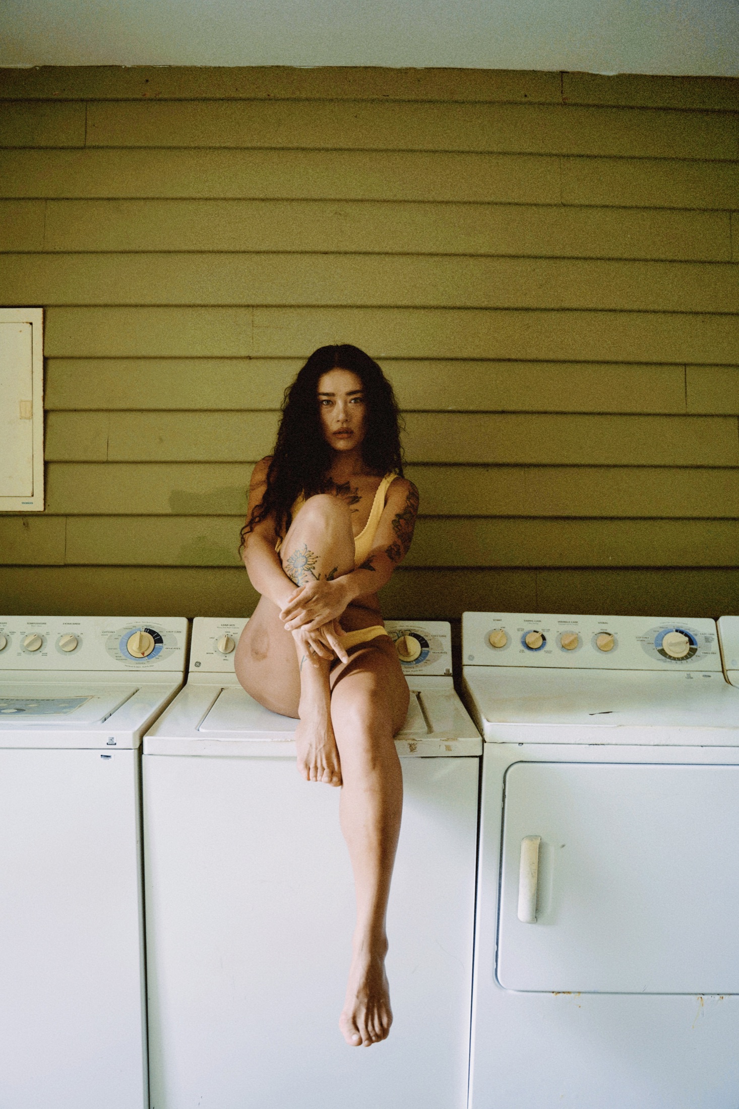 A quiet portrait of a woman inside a laundromat