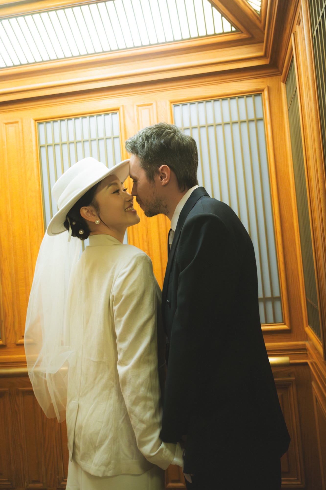 The couple kissing beside a brass elevator