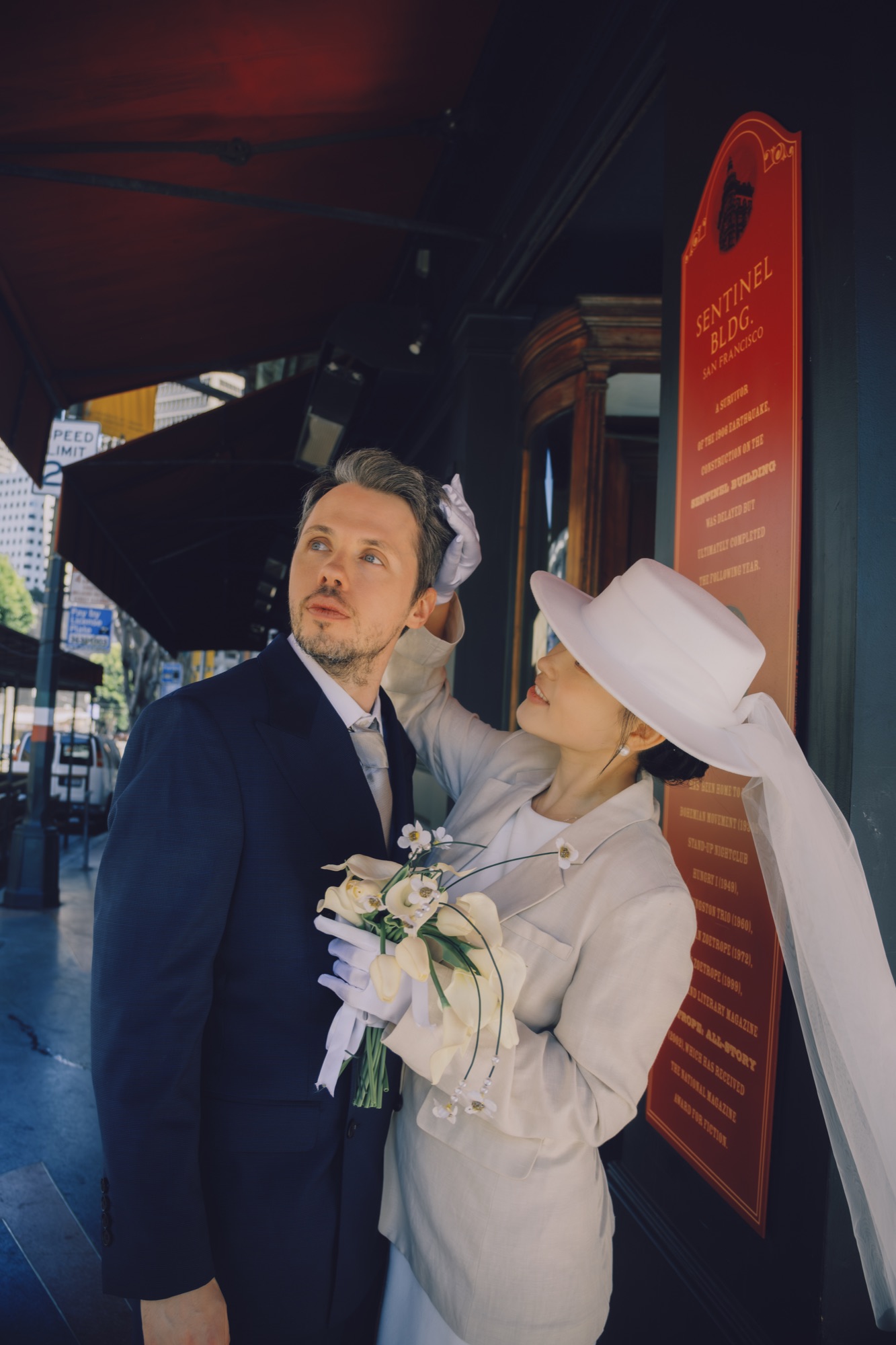 The couple standing together in a red Chinatown doorway