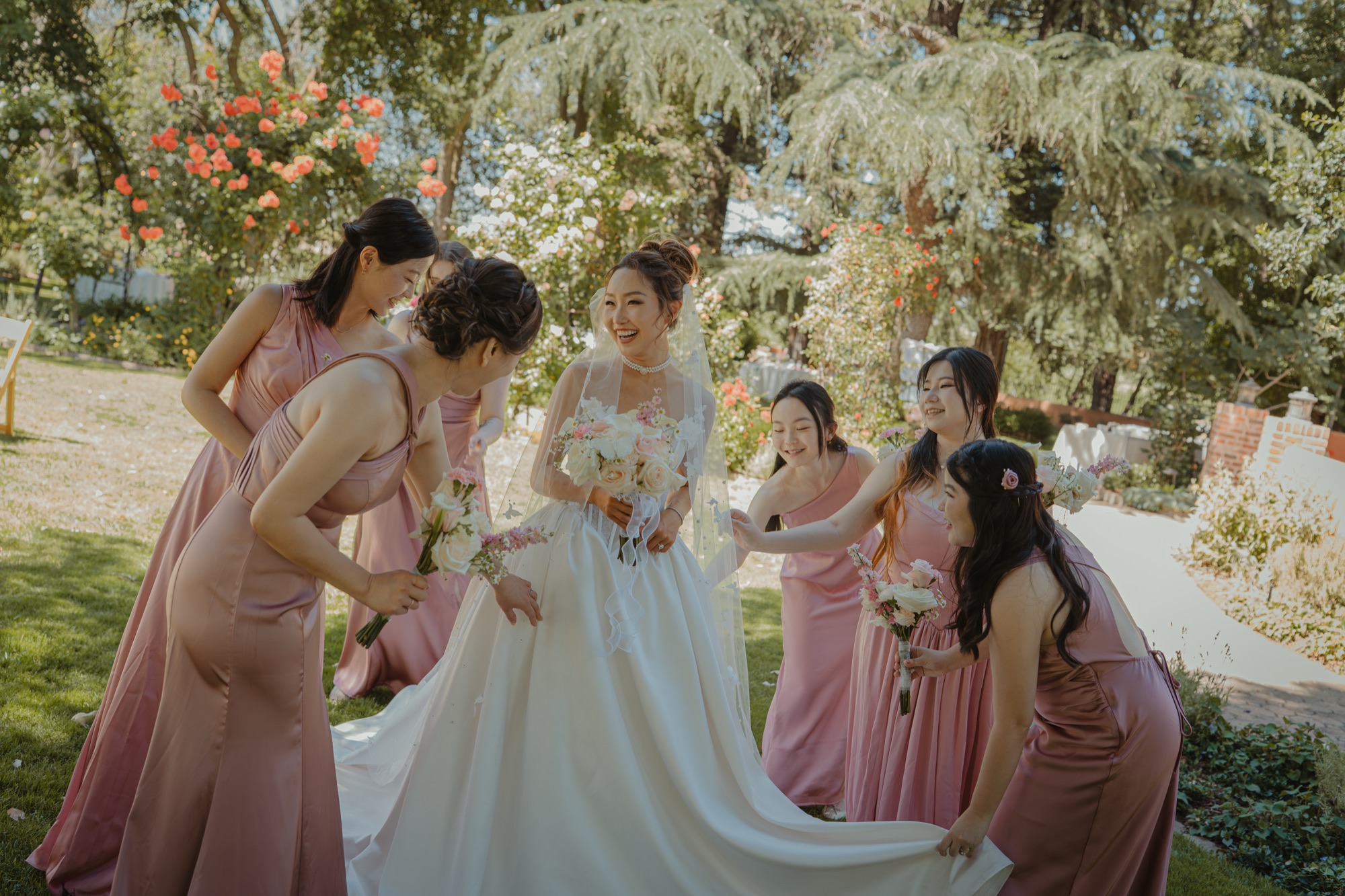 Nicole surrounded by her bridesmaids beneath the trees