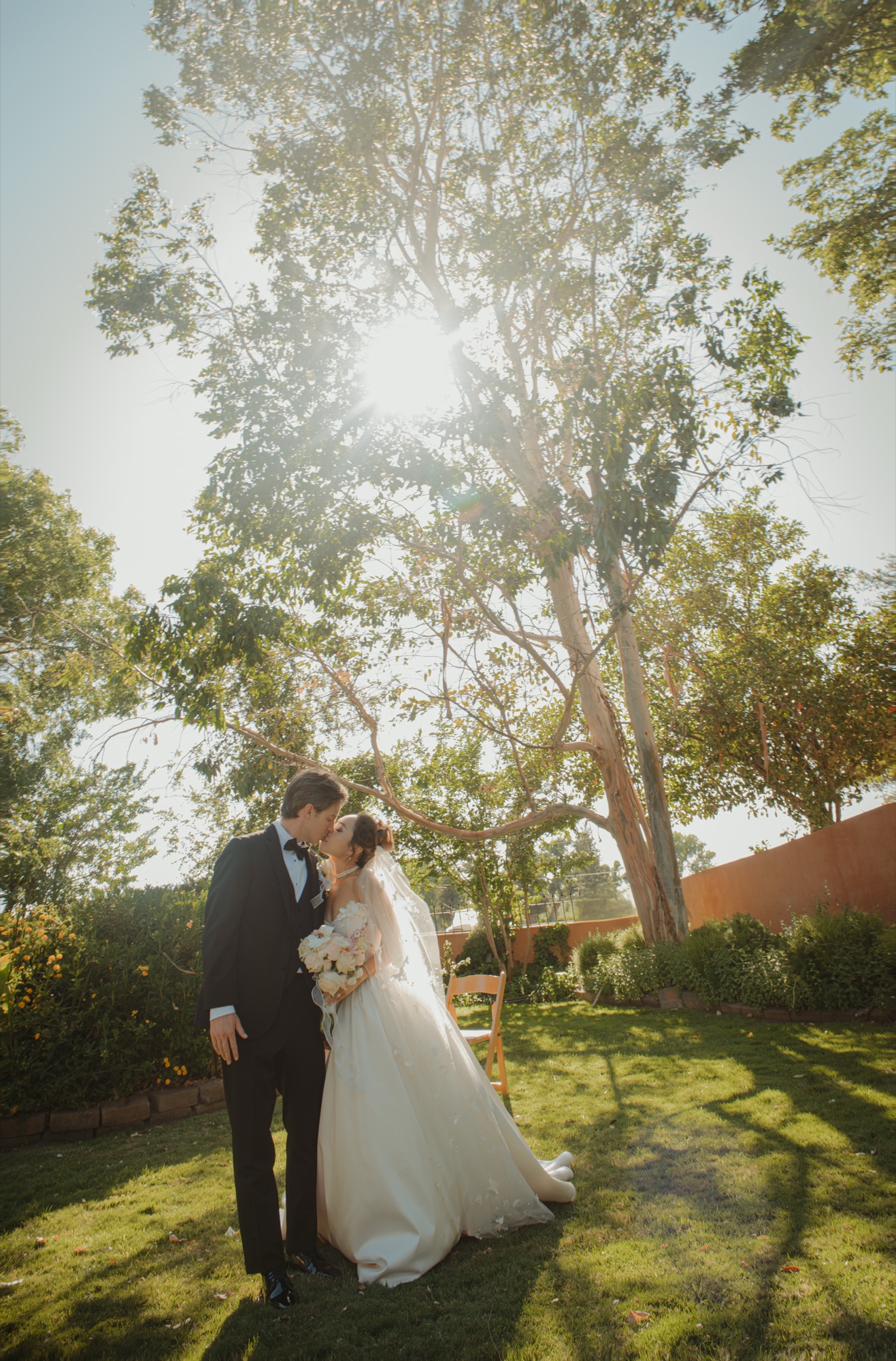 A backlit portrait of Nicole and Tanner beneath the trees